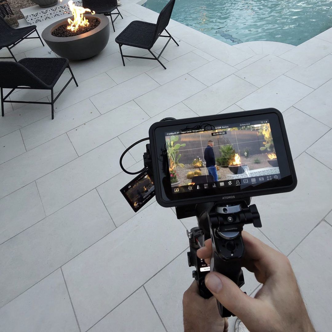 Camera monitor framing a finished pool with fire bowls