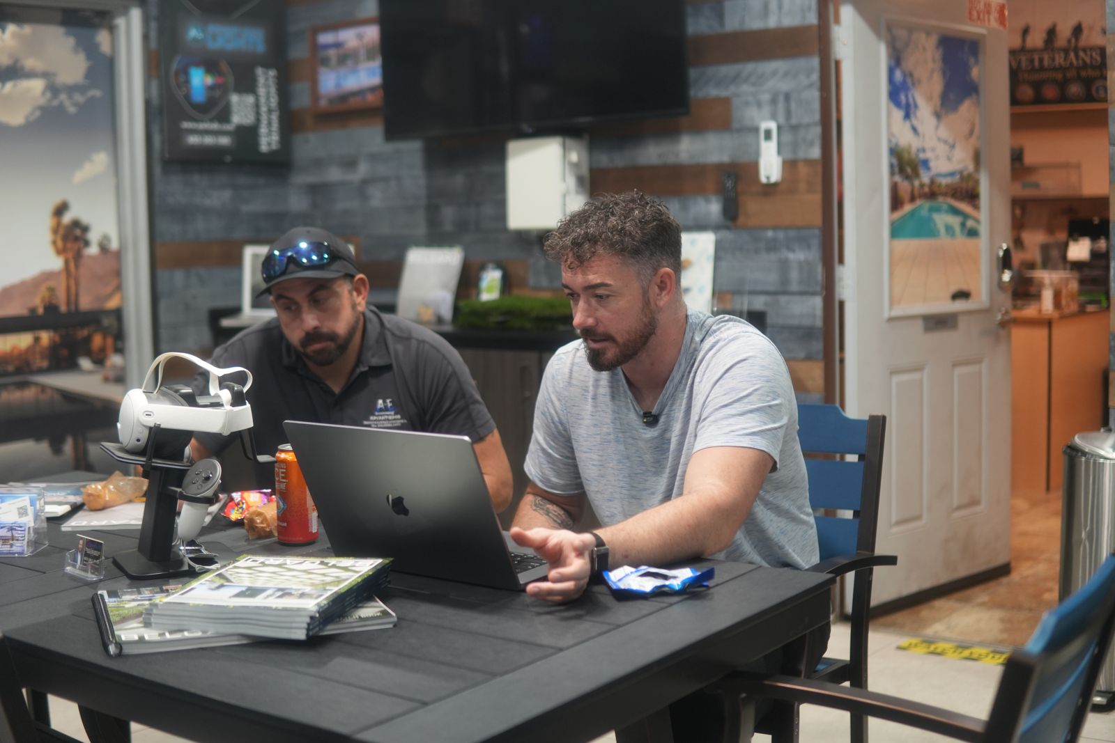 Douglas Laird talking strategy with a contractor at a table